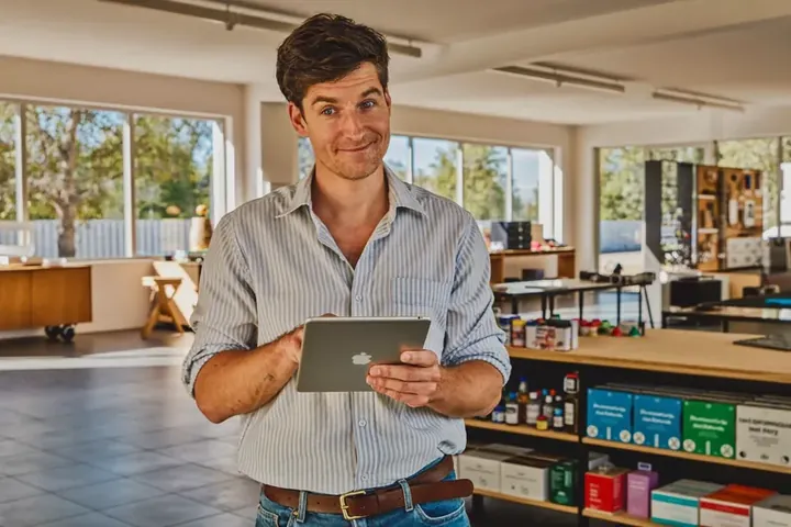 Inhaber eines kleinen Geschäfts mit Tablet in seinem Laden